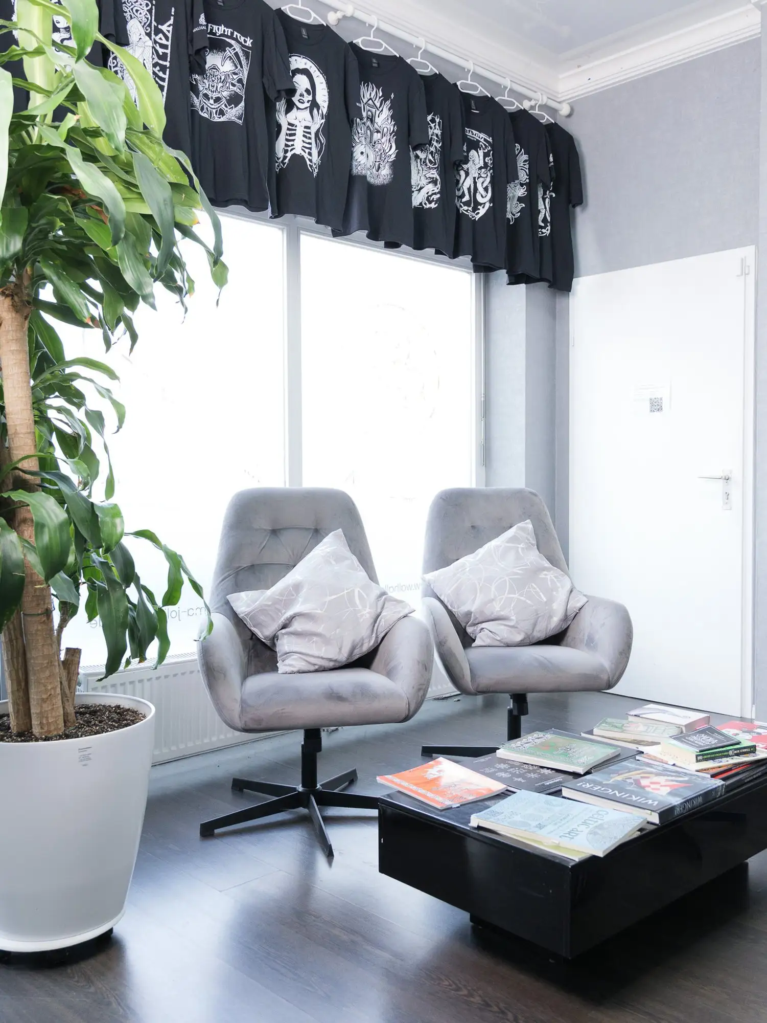 Studio-Eindruck: zwei graue Sessel mit Kissen vor einem Fenster